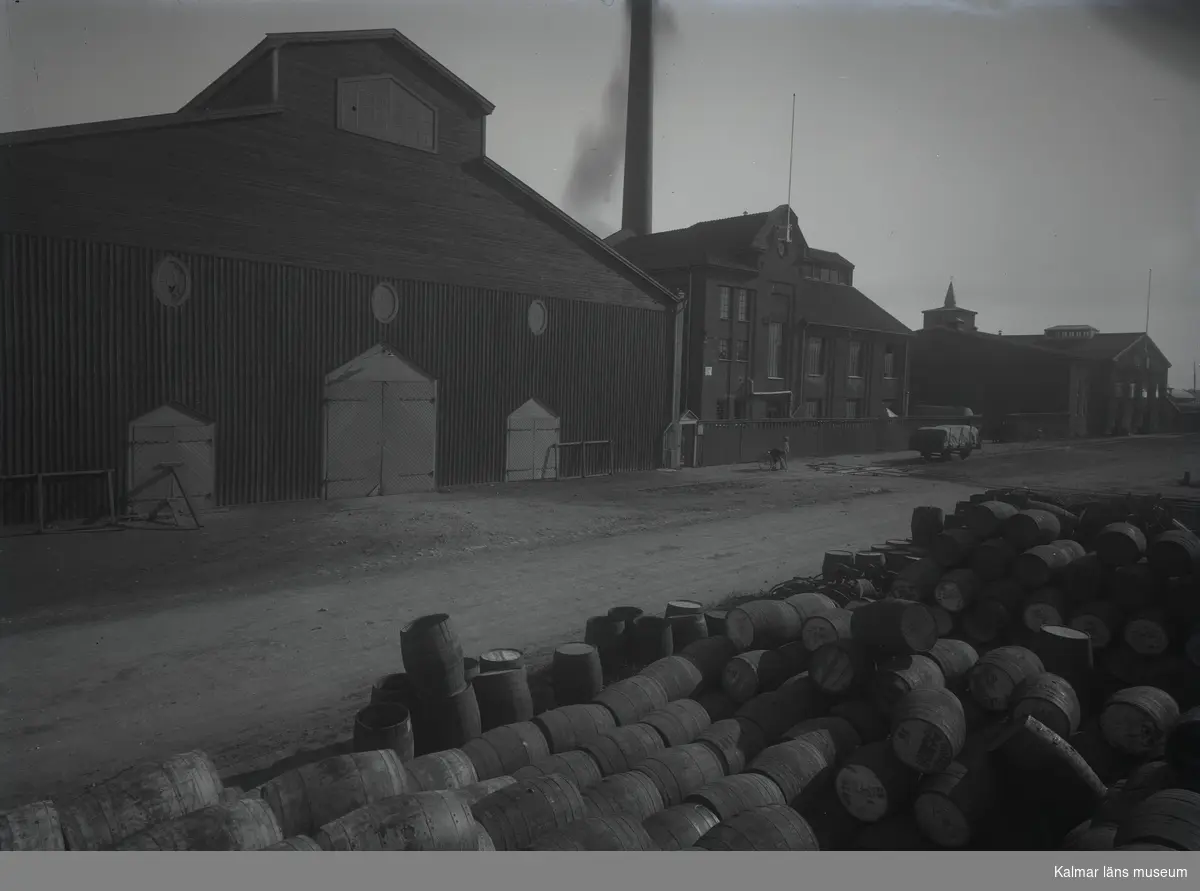 Fabriksbyggnader och upplag av tunnor på Barlastholmen.