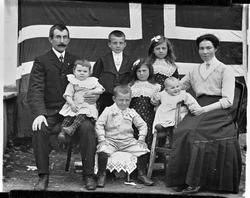 Familieportrett foran et stort flagg