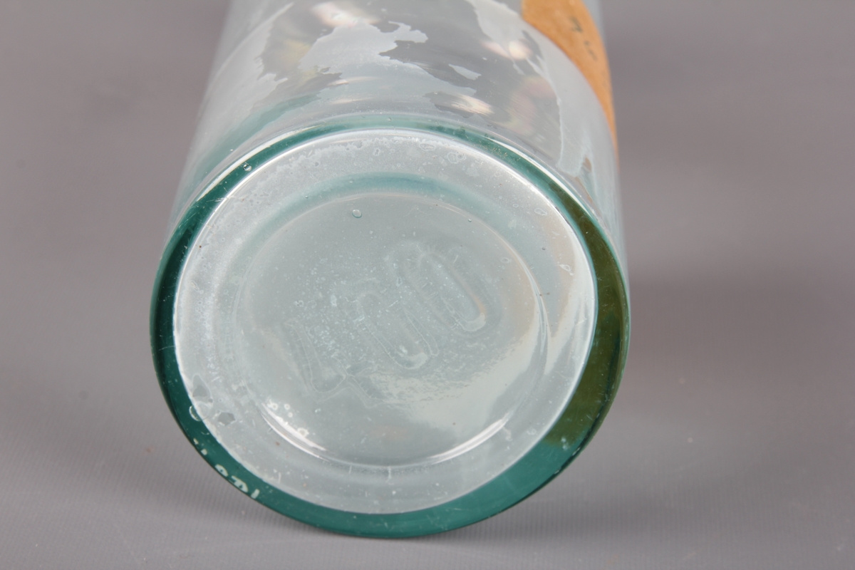 Sylindrisk glassflaske med etikett og kork. Brukt til oppbevaring av 96% sprit.