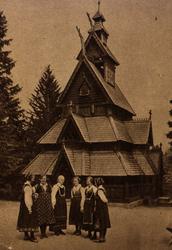 Postkort. Norsk Folkemuseum. Gol stavkirke. Bunadkledd grupp