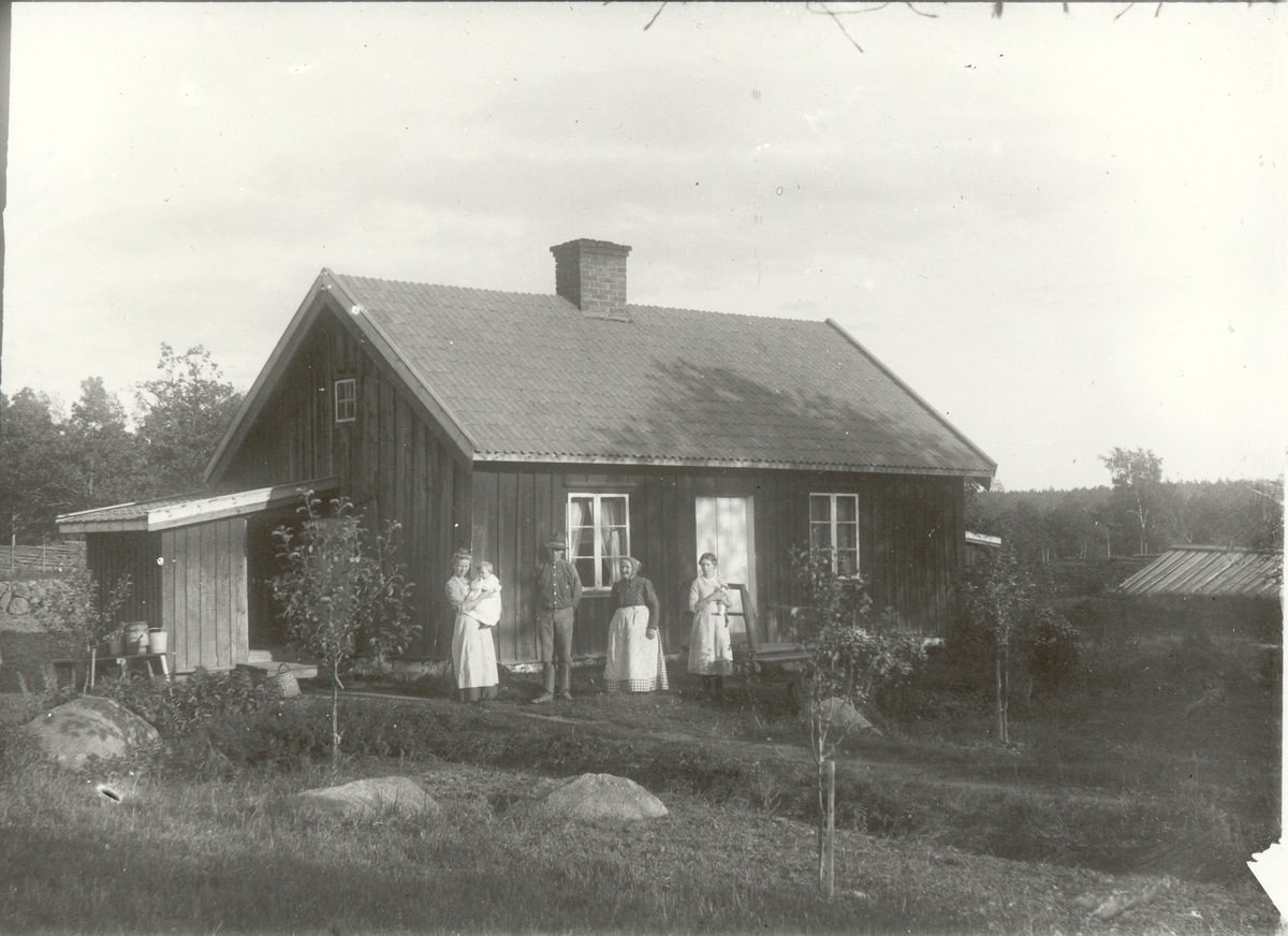 En familj utanför sitt hem i Åbo, Hjorteds socken 1913.
