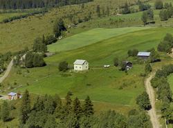 Kallykja. Hvit bygning, små uthus. Kulturlandskap. Dyrka mar