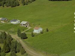 Småhusbebyggelse. Dyrka mark bakom.
