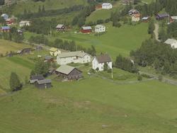 Rustmo. Gårdsbruk med toetasjes hovedbygning med hvit flaggs