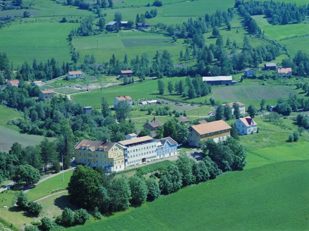 Flyfoto, Lillehammer, Søre Ål, Skogli Badesanatorium (Skogli helse- og rehabiliteringssenter) i Fredrik Collets veg 13. Låven på Holen gård ligger til høyre.