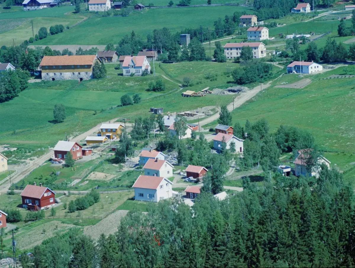 Flyfoto, Lillehammer, Søre Ål, Hagehaugen. Øverst er fjøset på Holen gård, nå revet. Til høyre øverst er et internat til Skogli helse- og rehabiliteringssenter.  Det lyse huset i forkant midt på bildet er Markvegen 3B. Rødt hus til venstre for dette er Markvegen 1B. Midt i bildet går Hagehaugvegen som går over i Solbakken etter svingen. Det gule huset ved svingen er Hagehaugvegen 21 og det røde rett nedenfor Hagehaugvegene 19. Det lyse lave huset øverst til høyre er revet.
