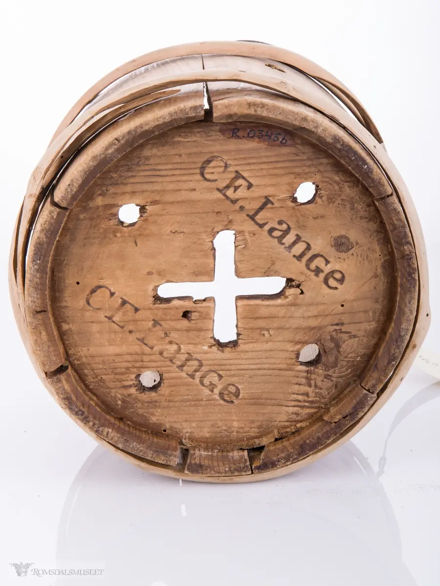 Lagget av 6 staver som har 2 hull i hver. Gjennomhullet bunn med kors og 4 hull. Hank av streng festet med . Gjordet oppe og nede.