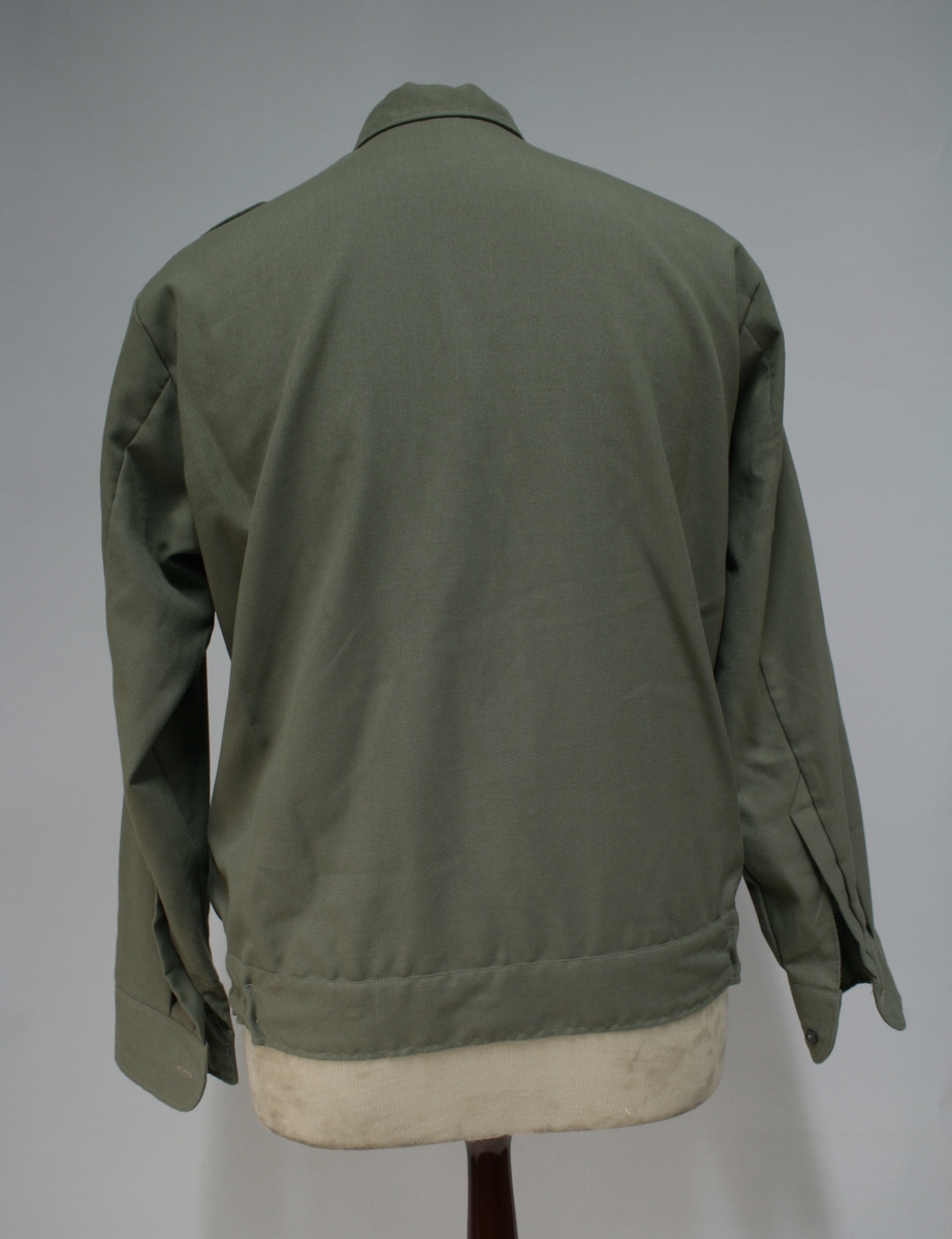 Blusen har regulerbart strikk nederst i sidene på innsiden.