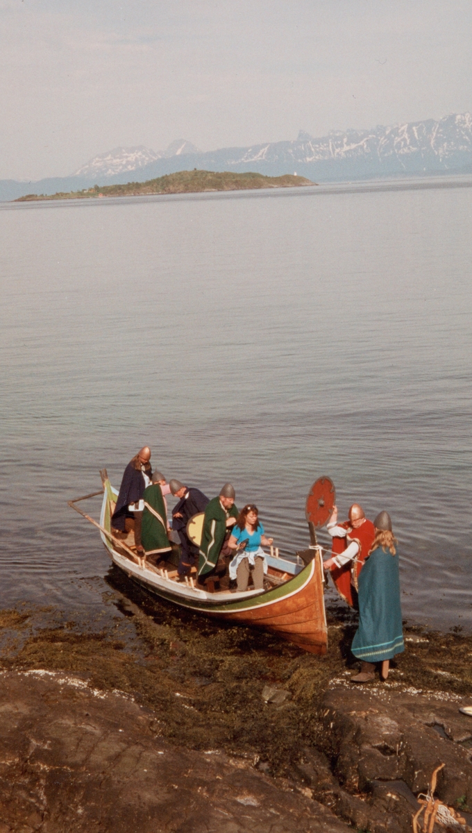 Nordlandsbåt med folk kledd ut som vikinger. Måga i bakgrunnen.