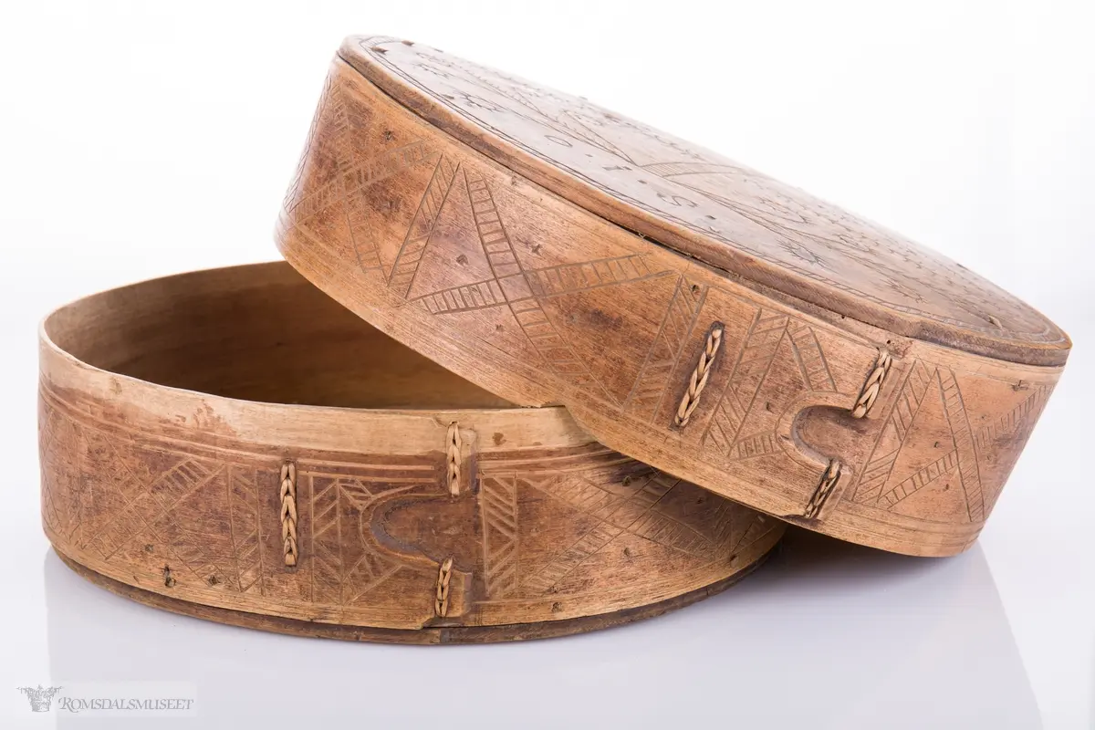 Eit kvistmønster/bregner på lokk. Skravert kryss- mønster langs trosken. Rosett av spetter i bunnen.