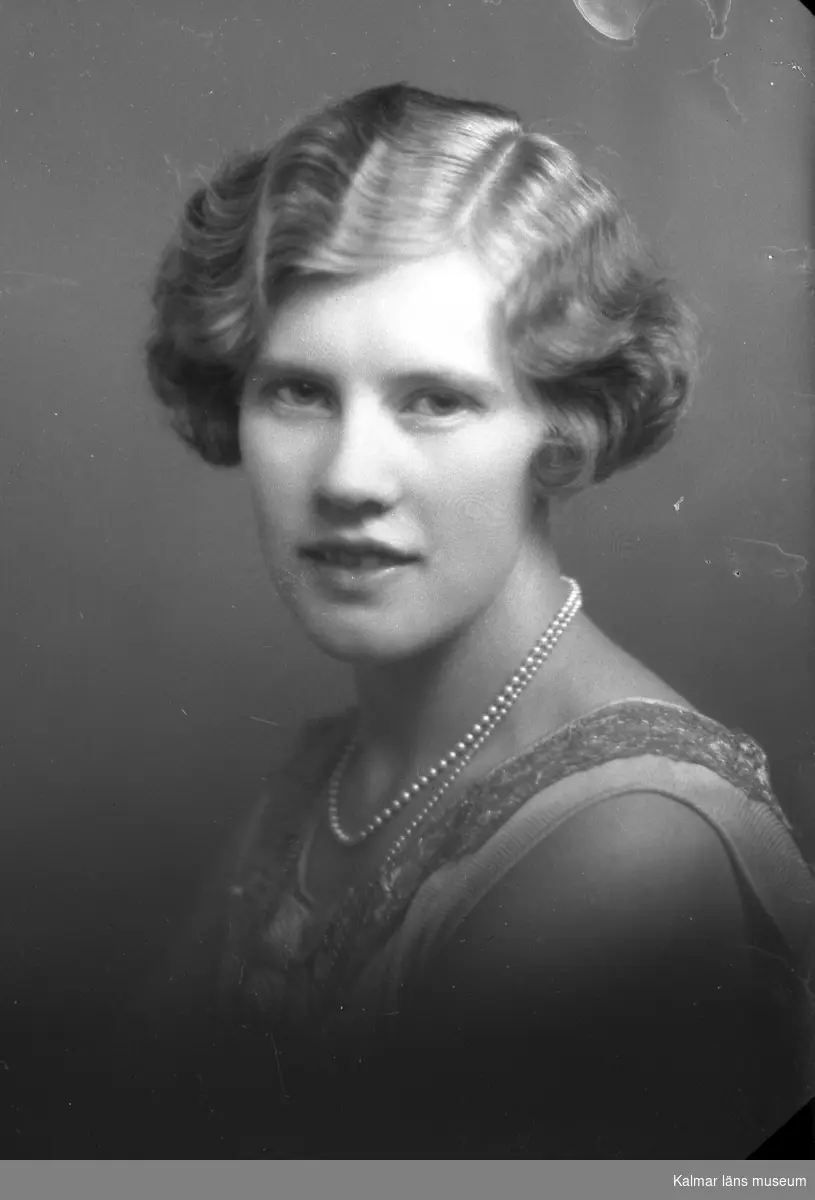 Ateljébild på en kvinna i halsband. Enligt Walter Olsons journal är bilden beställd av Sonja Augustsson.