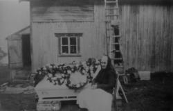 Kristine Mikalsen, f.1863-d.1956, ved båra til sin mann Jako