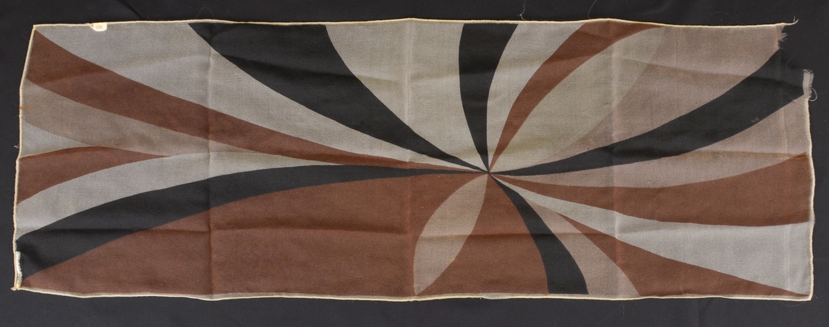 Gjennomskineleg sjal med dekor med brune, svarte og kvite stripar stråalnde ut ifrå eit senter. Rektangulær form.
