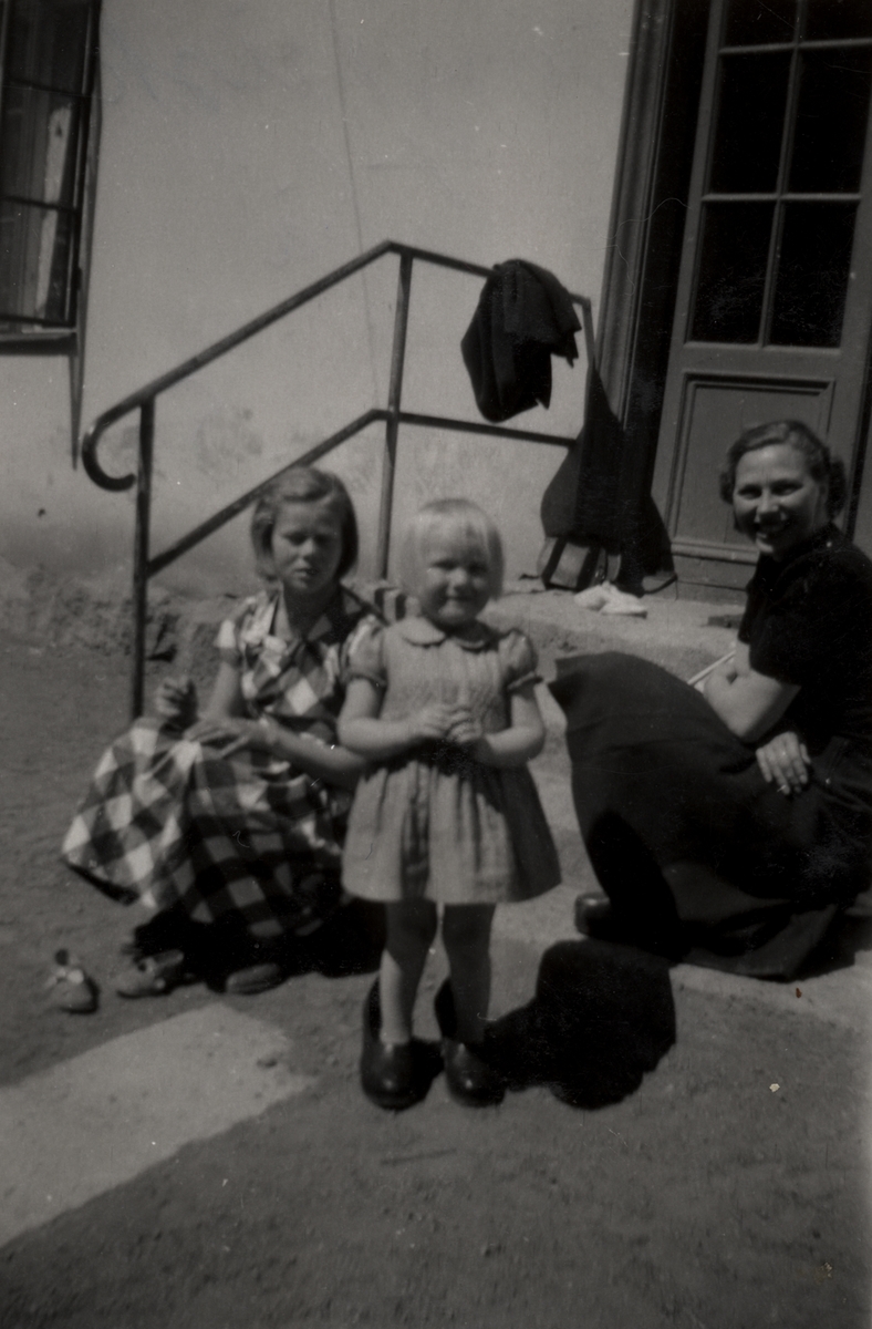 Flickorna Ingeborg Fristedt, Inger Andersson (Lilja) och Laila Roos 5 år. De sitter på trappen till huset på Drottninggatan 15.