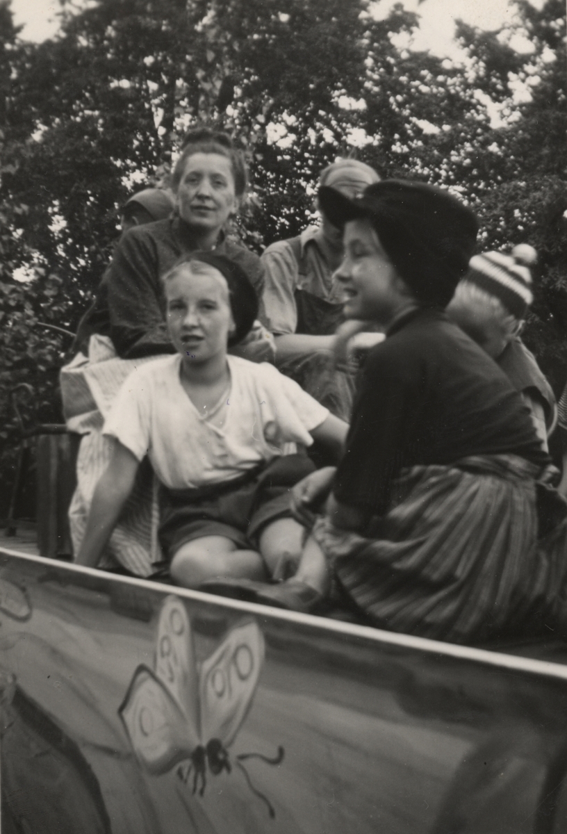 Bilden är tagen under Barnens dag 1945 i Linköping. Några personer förefaller att sitta i en vagn.