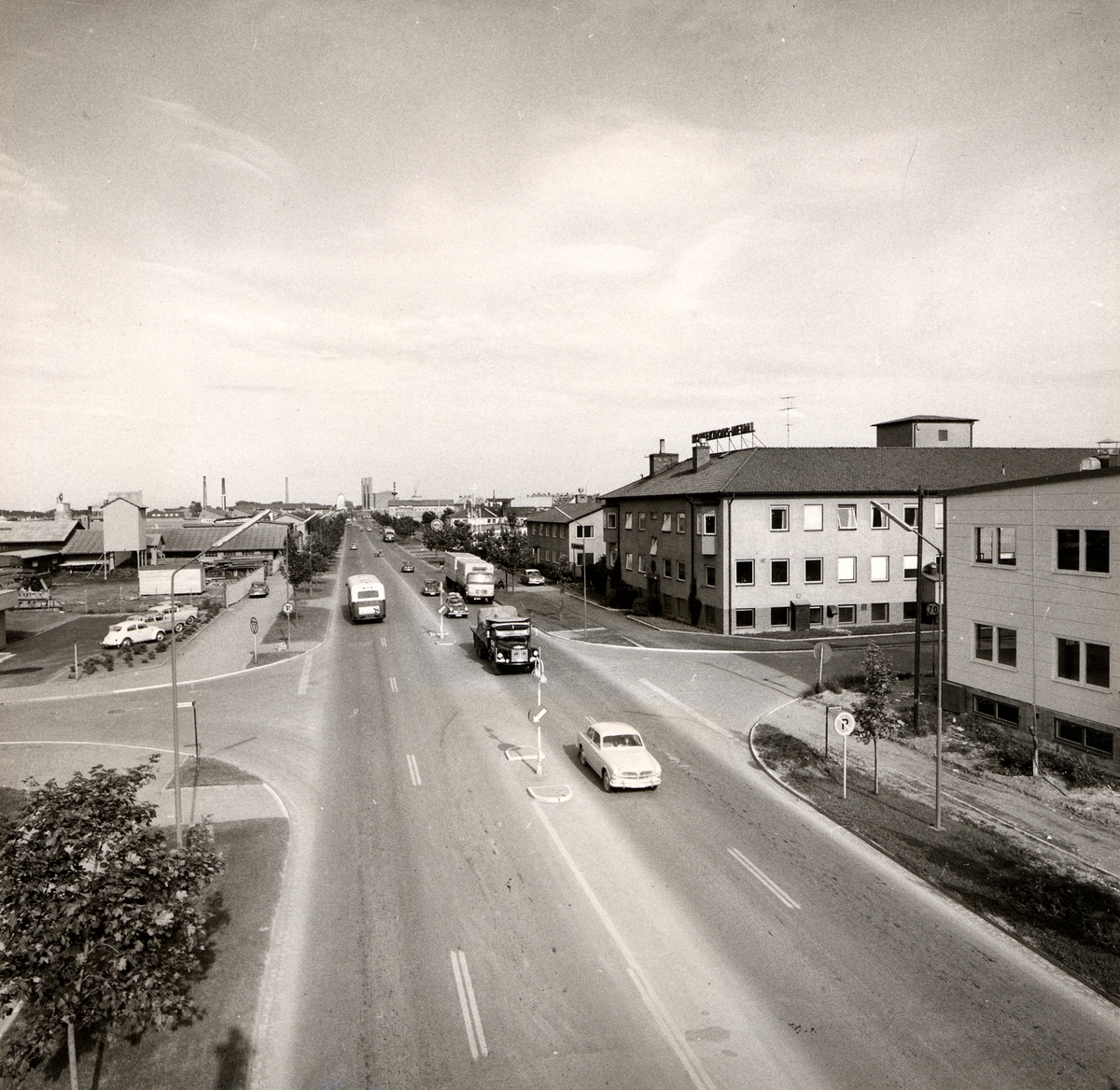 Orig. text: Industrigatan 1967. Vänstertrafik.
Stora byggnaden på höger sida är Konfektions-Metall. Vid korsningen Industrigatan/Mellangatan.
