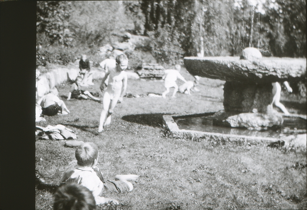 Gutter fra friluftsskolen Vangen leker rundt fontenen i hagen på Asker Museum.
