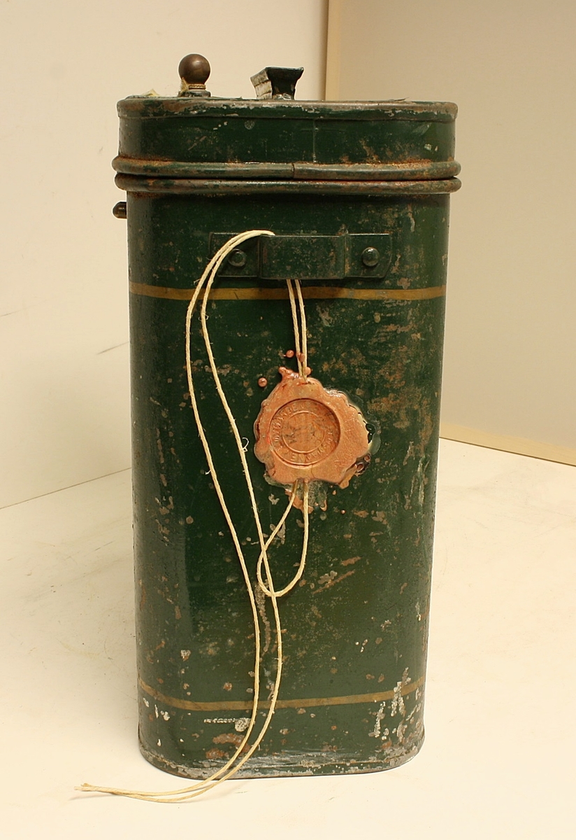 Avrundet, rektangulær boks. Den norske løve på fronten. Rødt segl på begge kortsidene. Hvit hyssing.