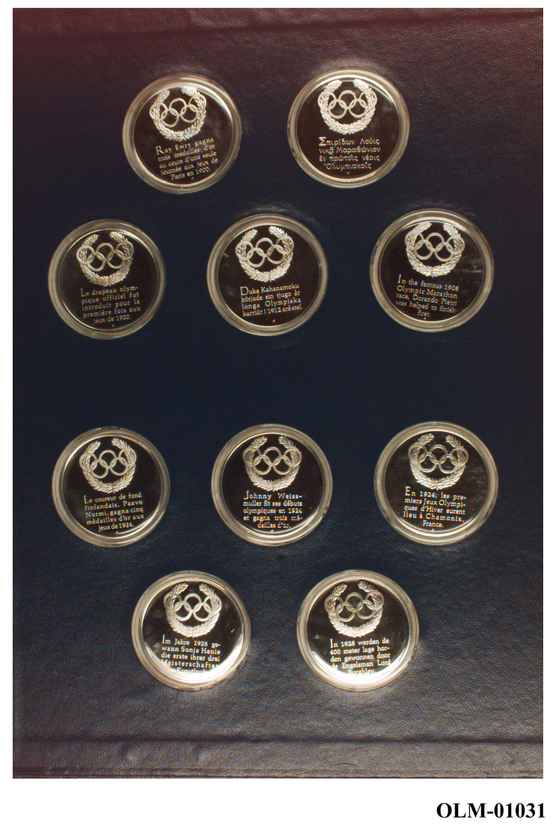 Album med 5 blad (10 sider) med minne-medaljer fra forskjellige OL. På omslaget de olympiske ringer i en olivenkrans.