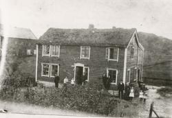 Motiv av gamlehuset på Øye, Vigra. Flere mennesker har stilt