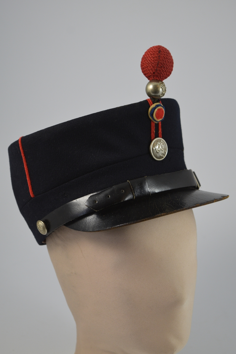 Uniform i to deler, jakke og lue.  a) lett innsvinget m/slag, enkelspent, høy krage; b) bøtteform m/ skygge og distinksjoner