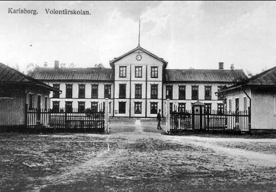Infanterivolontärskolan Karlsborg, senare rekrytskolan för infanteriets off- och res. off. Aspiranter 1878 - 1927. Mittenkasernen, framför denna två mindre byggnader varav den till vänster var en arrestlokal och den andra vaktlokal (1903).