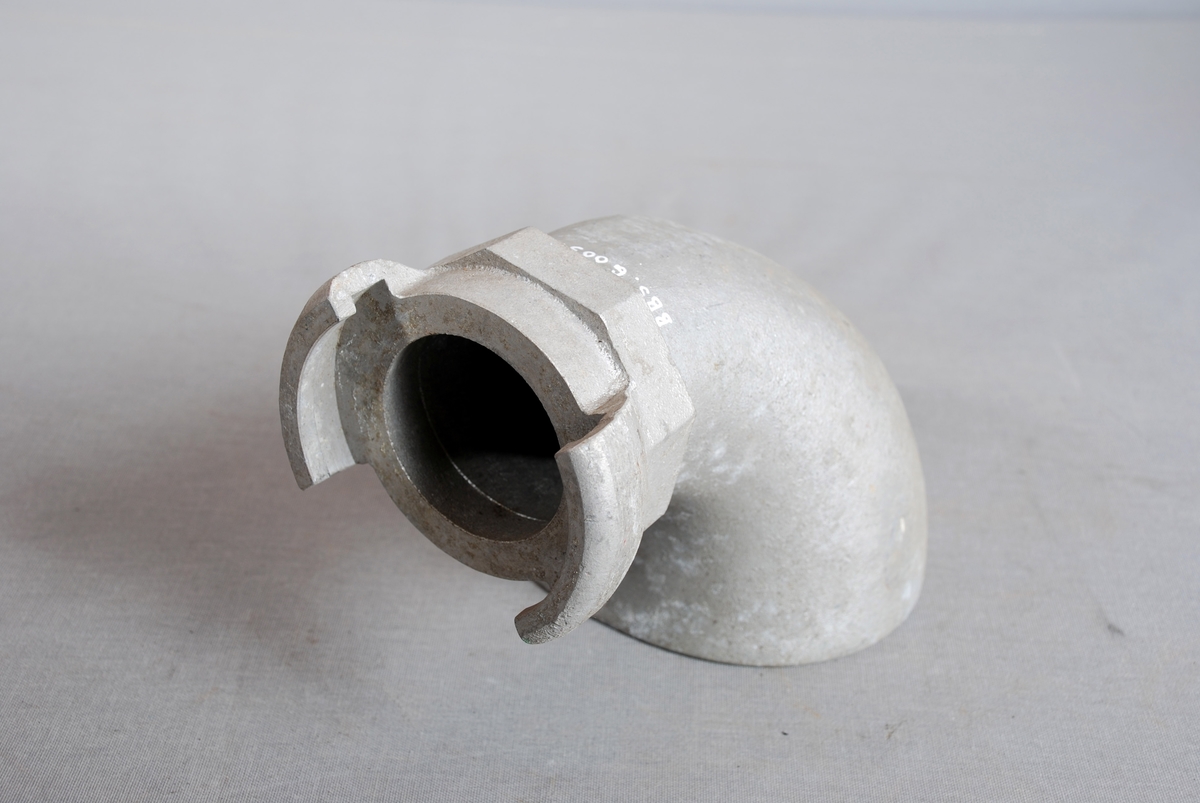 Fylletut i metall formet som et horn/trakt med oval åpning i ene enden og stuss for kobling i andre enden. Helstøpt i metall.