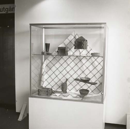 Utställning vid Kulturhuset i Stockholm 29 september 1978. En glasmonter innehållande friargåvor med bland annat mortel, olika skålar samt en rutig textil.