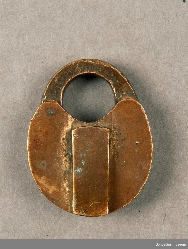 Nyckel saknas. Låset märkt: "Corbin Cabinet Loch. C.O." Skydd för nyckelhålet, en klaff av samma material som låset med fjäderanordning.