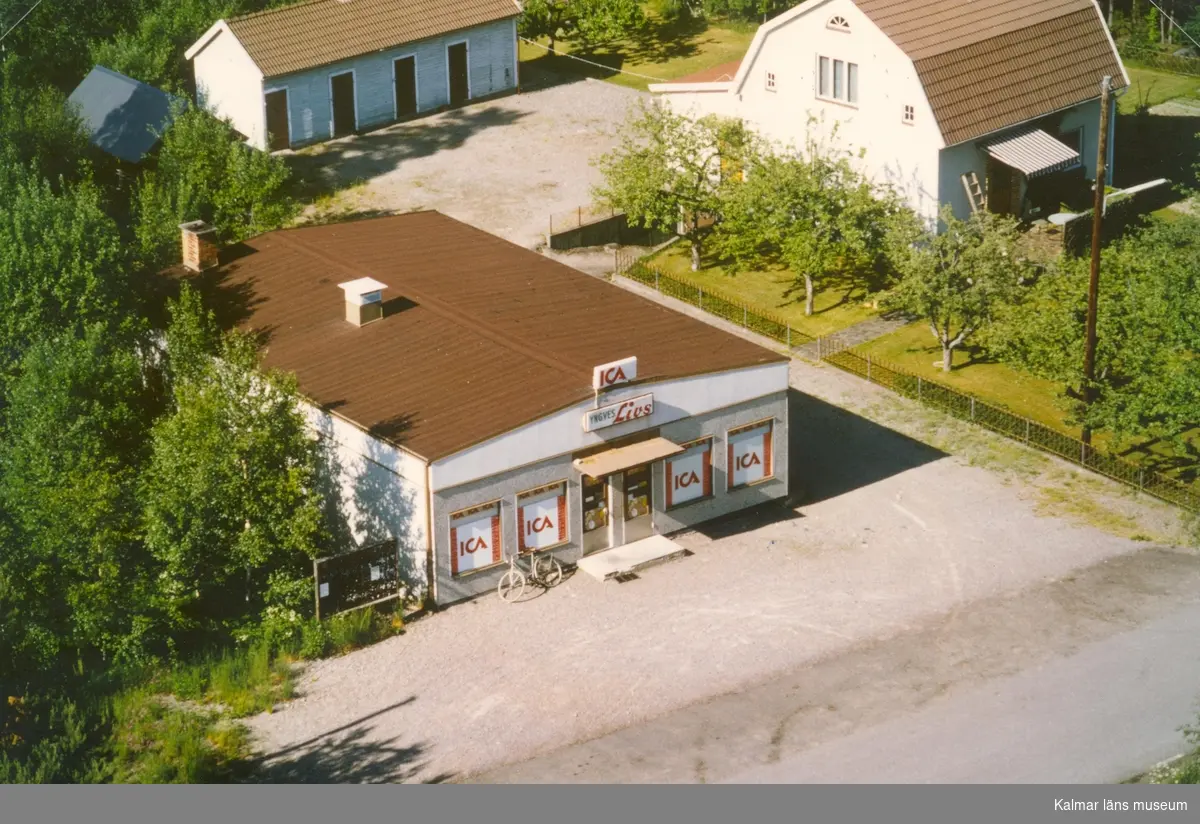 Flygfoto på ICA butiken samt ett enfamiljshus med sidobyggnad i Bäckebo.