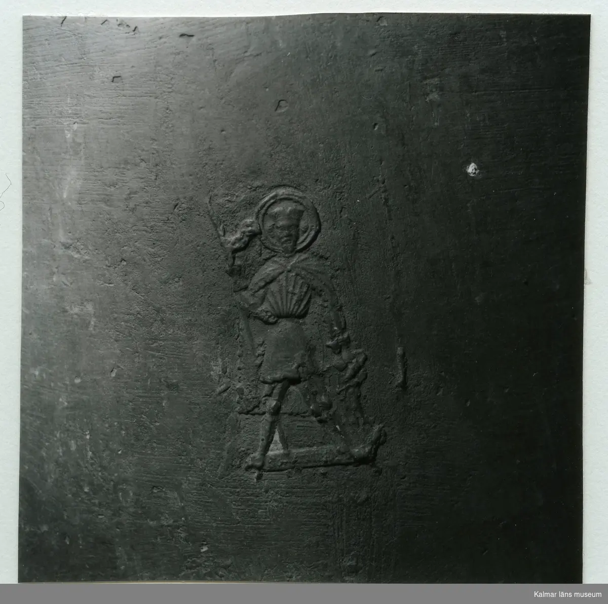 Relief av en man med helgongloria från Hälleberga kyrka.