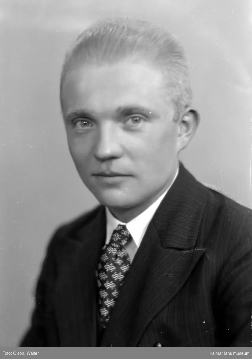 Ateljébild på en man i kostym och slips. Enligt Walter Olsons journal är bilden beställd av Heinrich Kuhn.