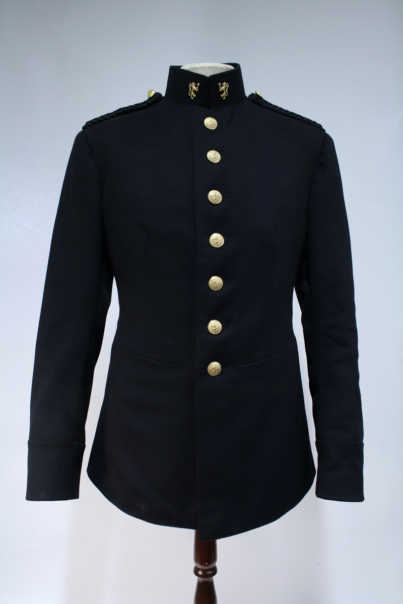 Uniform. Paradeuniform, modell 1935. Politikonstabel.
Høy krave med 7 gullknapper forran og 3 på hver arm. Foret.