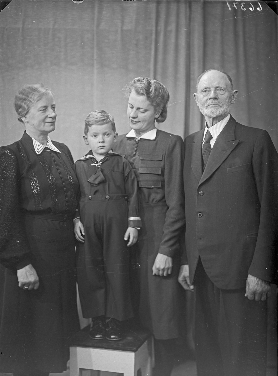 Gruppebilde. Familie. 4 generasjoner. Bestefar, bestemor, datter og dattersønn. Bestilt av Fru Karl Lothe. Hasselgt. 8.