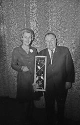 En kvinne og en mann poserer med en kunstgjenstand.