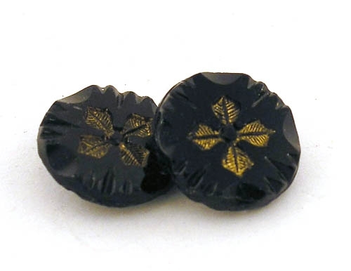 Två stycken knappar av svart glas med blommotiv.

Enligt liggaren: Knappar av stenkol, olika storlekar.