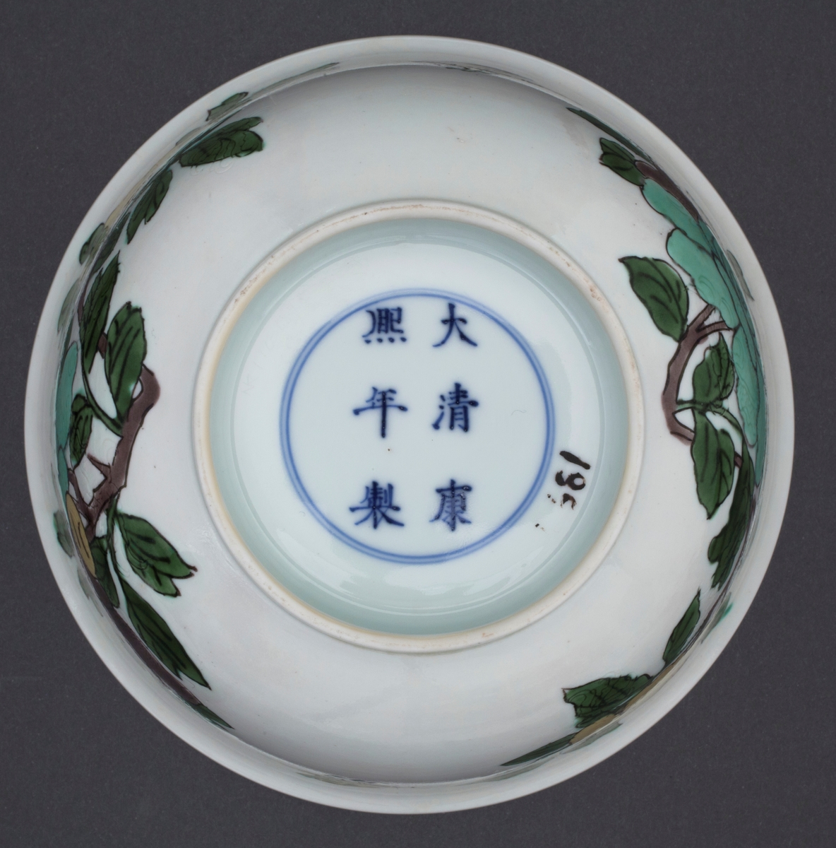 Oveglasur på hvit bakgrunn. Overglasurdekor: To grupper med  hibiskusblomster i pastell lavendlgrå, pastell turkis og pastell sitrongul med blader i en kraftig grønnfarge. Mellom de to blomstergruppene er sommerfugl som reflekterer fargene i blomstene. I godset under hver blomstergruppe er det innrisset en drage.