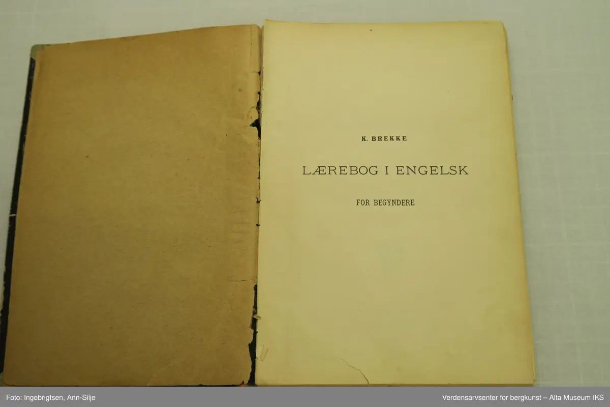 Bok med svarte permer. Ryggen på permen er ødelagt og permene blir holdt sammen av en grå tape.