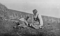 Personer, klær, gjerde, naturforhold.