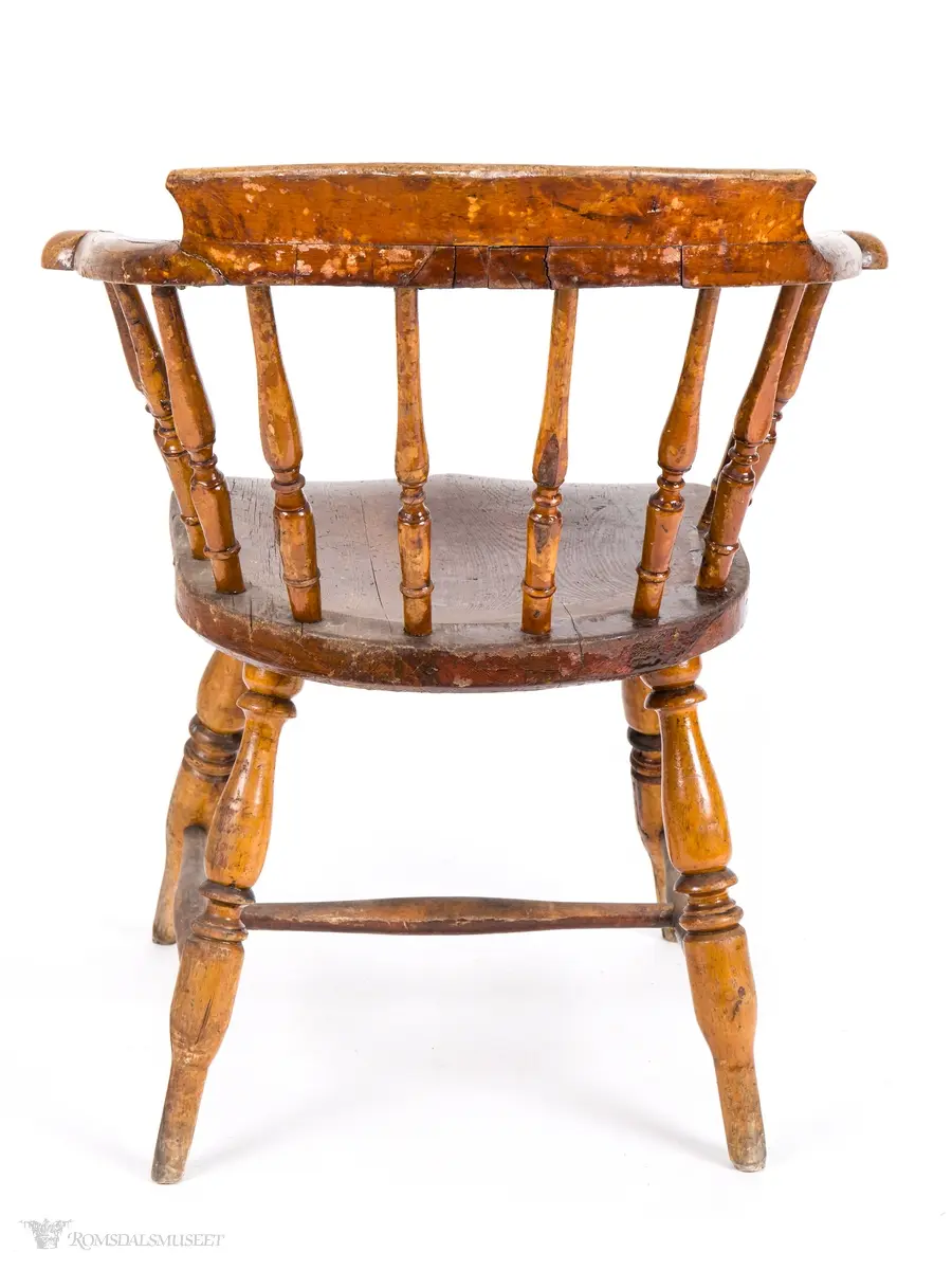 Winsdoor- stol inspirert pinnestol med kraftig skjoldformet sete, tykke dreide ben med H- sprosse imellom. 10 dreide pinner i ryggen som er festet i et avrundety skulderbrett som fortsetter framover og utgjør et par korte armlener