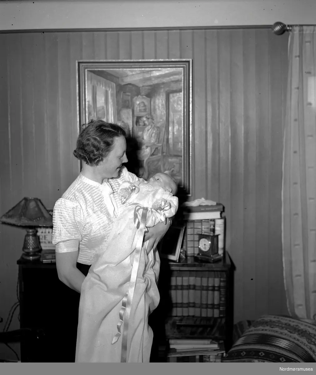 Portrettfoto av mor med sitt nydøpte barn i armene. Det er usikkert hvem vi ser på bildet. Fra Nordmøre museums fotosamlinger, Halås-arkivet.

