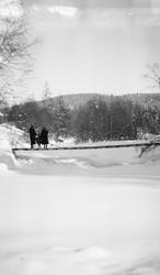 To kvinner og en pike på bru over Masnaelva.