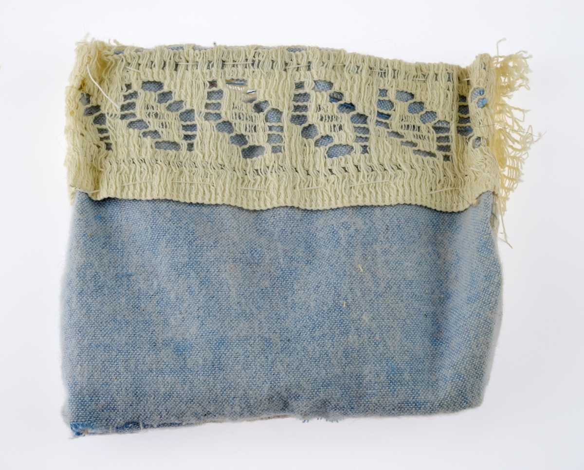 En sjokoladeeske brukt som dukkeseng med dukke, dyne, pute, skinnfell, ullteppe og madrass. Gjenstandene er undernummerert 01-08.
FTT.54432.01: En sjokoladeeske fra Freia brukt som dukkeseng. Esken er med lokk og laget av papp. Den er stiftet i hjørnene. Utenpå er det trykt julenissehoder i rødt og grønt. For tekst se "Påført tekst/merker".
FTT.54432.02: En dukke laget av plast der både armer og bein er bevegelige ved at de er festet med strikk inni dukken. Håret er støpt og er krøllet ved ørene. I ansiktet er det malt øyebryn, øyne, røde kinn og munn. Dukken har på seg en pyjamas laget av flanell. Den er stripete i fargene hvit, blå, lys oransje og grønn. På skjorten er det to knapper i fronten.
FTT.54432.03: En hodepute laget av blått bomullsstoff med heklet trekk. Puten er fyllt med diverse tekstilbiter.
FTT.54432.04: En dyne laget av blått bomullsstoff med en påsydd blondekant foran. Baksiden er sydd sammen av tre ulike tekstiler. Dynen er fyllt med tekstilbiter.
FTT.54432.05: En brunsvart skinnfell, trolig laget av kaninpels.
FTT.54432.06: Et ullteppe som trolig klippet ut av et eksisterende ullteppe. Teppet er gulhvitt med blomster og blader i rosalilla.
FTT.54432.07: Et sammenbrettet stykke som er heklet. Trolig en rest som er brukt som madrass i esken/sengen.
FTT.54432.08: Et sammenbrettet stykke som er heklet. Trolig en rest som er brukt som madrass i esken/sengen.