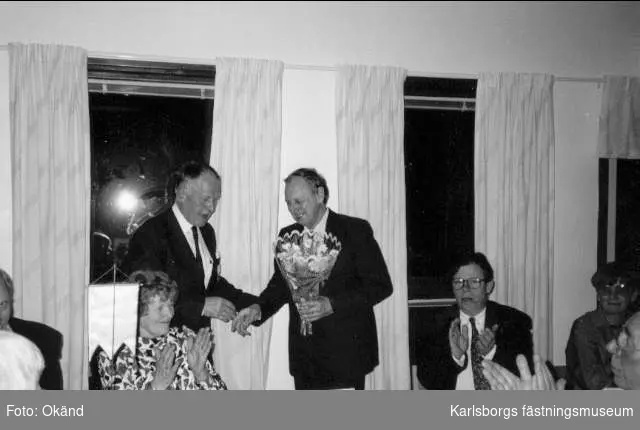 Västergötlands Sångarförbunds ordf. Olle Johansson överlämnar blommor till Karlsborgs manskörs ordf. Tage Strålman vid banketten i samband med manskörens 90-års jubileum, 13/4 1991.