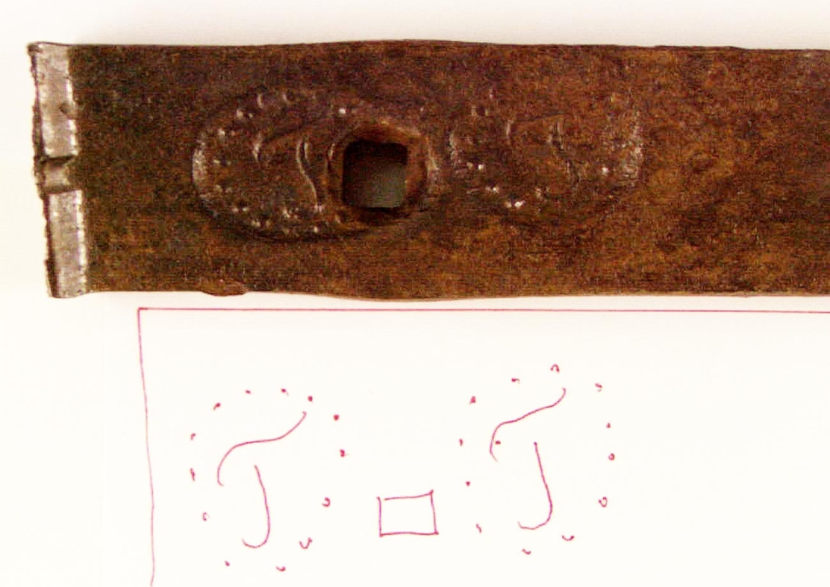 Bit av stångjärn från Tjernäs Övre Hammare i Torsåkers socken. Försedd med järnstämpel, T i rundel med prickrand runt om. Har förmodligen använts som byggnadsjärn.