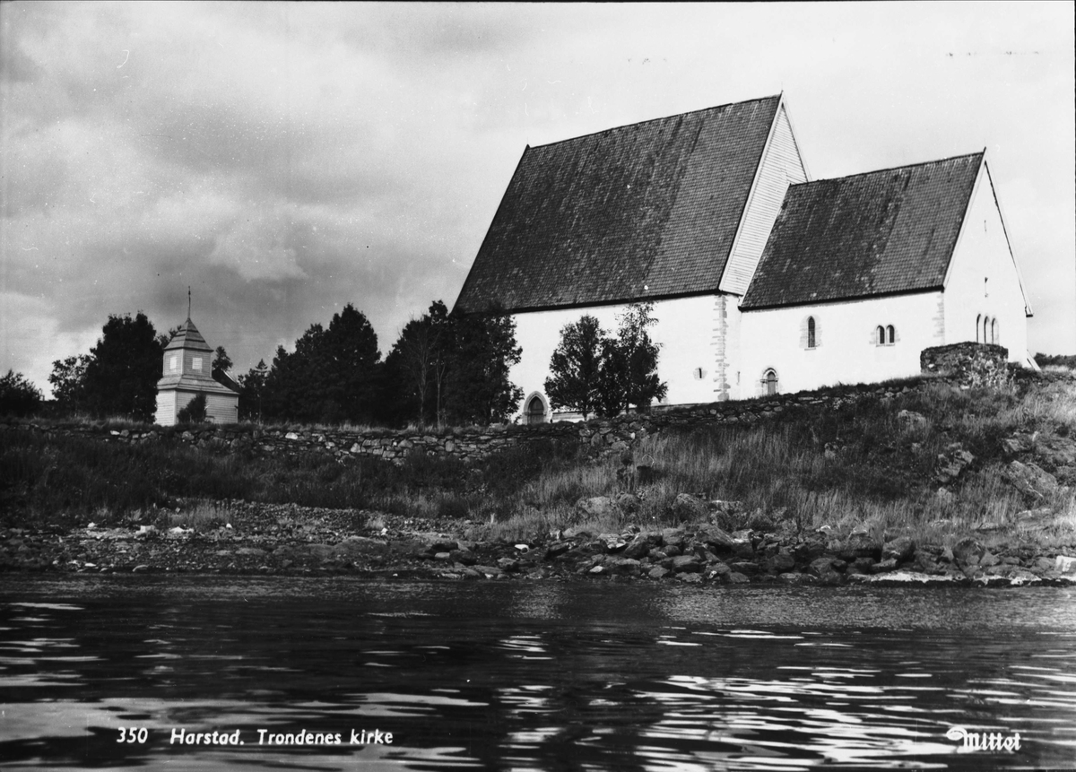 Trondenes kirke med forsvarsmuren i forgrunnen.