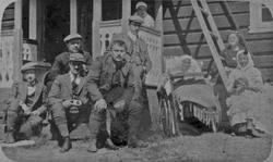 Gruppebilde. Personer foran bolighus.