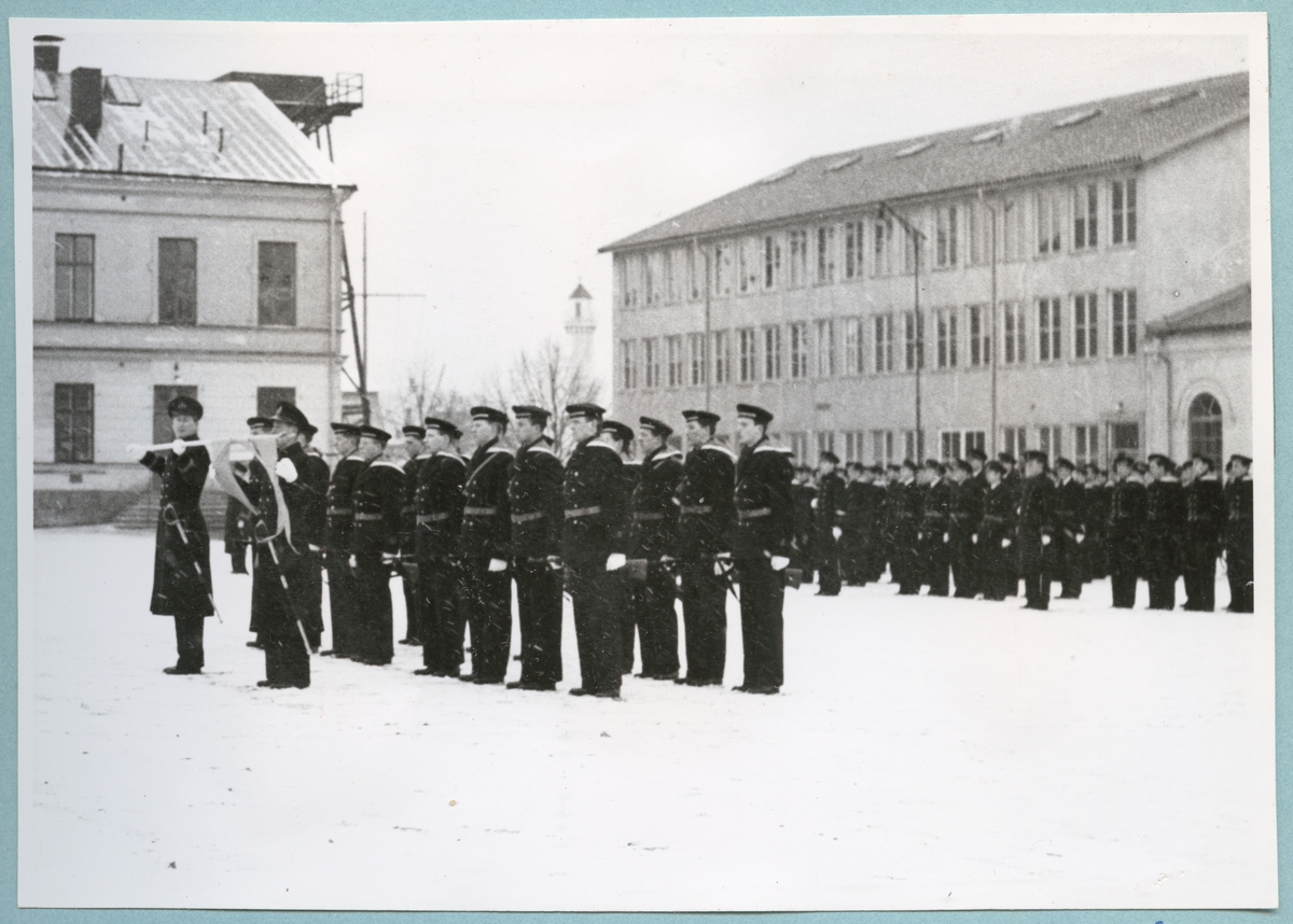 Uniformsklädda flottister står uppställda på bataljon Sparres snötäckta kaserngård.