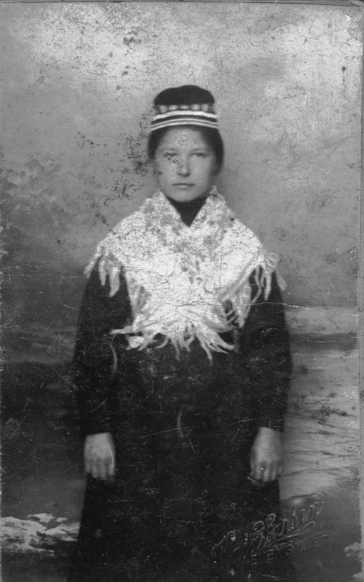 Studioportrett av ung kvinne i samisk drakt.