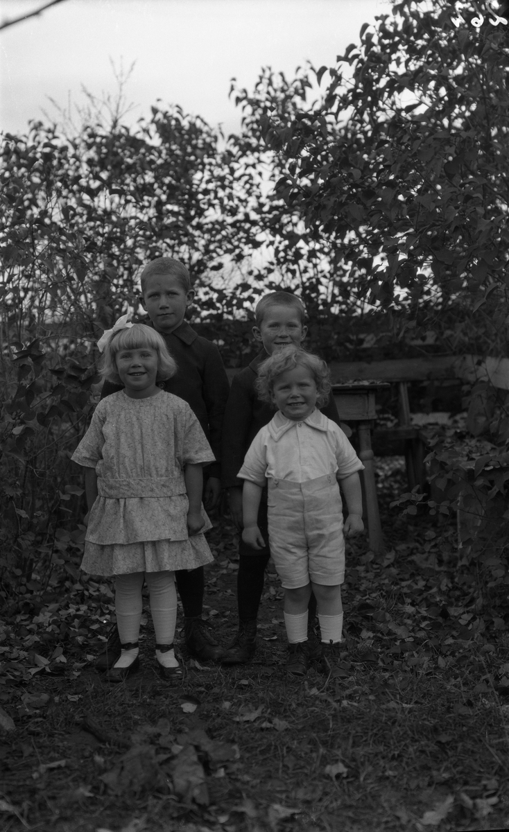 Fire uidentifiserte barn, tre gutter og ei jente, alle i helfigur. To bilder.